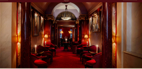 Innenansicht Hotel Maison Athénée Paris mit rotem Interieur, eleganten Sesseln und klassischer Pariser Atmosphäre.
